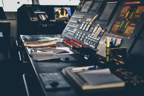 Control panel of a ship with plenty of buttons and books with operating procedures laying near controls.